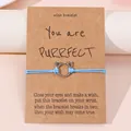 Minimalistische lichtblauwe gevlochten kattenoor armband op een kraftpapier cadeaukaart - Hemelsblauw