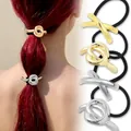 Detail of gold and silver knot hair ties showing high elasticity on a ponytail - Gold Silver Twist Cross Style Combo