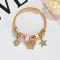 Gold beaded charm bracelet with pink butterfly and sparkling heart pendants on wire cable - Pink