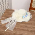 Creamy straw sun hat with organza bow and blue floral detail on wooden table - Lily Of The Valley Milk White