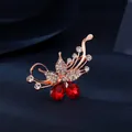 Elegant rose gold butterfly brooch with zircon inlays and pear-shaped red crystals - Rose