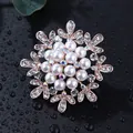Elegant snowflake brooch with pearls and shimmering crystals on a sleek black surface - Hoop Pearl