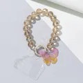 Macro view of transparent beaded phone strap with iridescent gradient butterfly charm - Brown