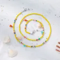 Detailed shot of yellow glass beads with colorful clay accents and small white seashells - Yellow Base Bead Style C / Yellow