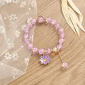 Detalle macro de cuentas de cristal violeta y colgante de margarita esmaltada en una pulsera - Púrpura