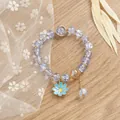 Pulsera de cuentas de cristal lavanda con dije de margarita sobre fondo de madera - Azul