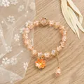 Vista detallada de la pulsera de cuentas de cristal con colgante de flor naranja y cadena - Naranja