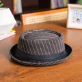 Detailed texture of brown pinstripe wool pork pie hat with black ribbon on wooden table - 58cm / Coffee