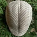 Classic beige mesh flat cap for men with breathable diamond weave on a green background - Beige