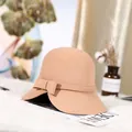 Elegant camel wool felt cloche hat with a matching ribbon bow on white faux fur background - Khaki