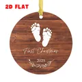 Dettaglio di un ornamento in legno rotondo con impronte di neonato e scritta First Christmas 2025 - Stile Impronte Venatura Legno Scuro (QT1559-3)