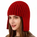 Detailed close-up of the red knitted winter hat texture and thick ear protection flaps - Burgundy