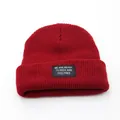 Burgundy ribbed knit beanie with black letter patch detail on a clean white background - Adjustable / Burgundy