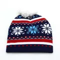 Dettaglio del cappello di Natale lavorato a maglia con fiocchi di neve e morbido pompon bianco - Bambini / Stile Fiocco di Neve