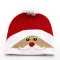 Close-up of a red knitted Christmas beanie with Santa Claus face and a white pom-pom - Kids / Jacquard Santa Claus Style