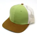 Detail of green and brown trucker hat with breathable white mesh panel and curved brim - Adjustable / Light Green And Tan Patchwork