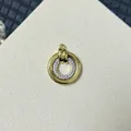 Nahaufnahme eines kreisförmigen Doppelring-Anhängers mit Gold-Finish und Zirkonia-Inlay - Doppelkreis Rund Geometrisch