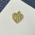 Macro shot of gold-plated openwork heart pendant with micro-inlaid white zircon stones - Hollow Heart Pattern Style