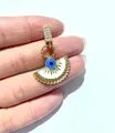 Detailed macro view of gold fan-shaped evil eye pendant with micro-set zircon accents - Gold