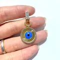 Makro-Detail des Evil Eye Anhängers mit blauer Pupille und Mikrozirkonia-Besatz in Gold - Gold