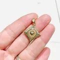 Star-shaped gold pendant with central sphere and zircon inlay held in hand for scale - Gold-Tone Eight-Pointed Star Sunflower (Style 1)