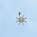 Macro shot of gold-plated sunburst pendant with a central crystal and pave accents - Star Style / Gold