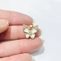 Detailed close-up of a gold-plated butterfly pendant with white enamel and sparkling crystals - White Enamel Zirconia Style / Gold No.3