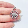 Macro detail of sunburst pendant with zircon inlay and heart tips held by hand - Snowflake Sunburst Style / Silver