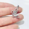 Detailed view of a silver butterfly pendant with crystals held to show size scale - Silver Style 3