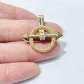 Macro view of gold plated arrow through crystal circle pendant with sparkling zircons - Arrow Through Ring Style