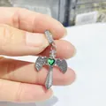 Nahaufnahme von silbernem Schwert-Kreuz-Anhänger mit grünem Herz-Zirkon und Flügeln - Silbernes Grünes Herz Kreuz