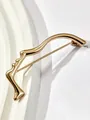 Dettaglio della spilla dorata astratta profilo viso con finitura lucida a specchio - Oro 16K / Oro