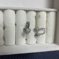 Makroaufnahme von herzförmigen Silberohrringen mit funkelnden Zirkoniasteinen auf Etui - Silber Dickes Herz Pavé Zirkonia Stil
