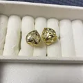 Detail of heart-shaped gold earrings with white zircons and hollow star pattern - Gold Heart Star Hollow Pavé Style