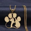 Macro shot of gold cat and dog paw pendant on textured black leather surface - Gold