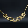 Macro detail of gold-tone moon phase pendant with pentagram design on black mirror surface - 50cm / Gold