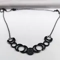 Close-up of black moon phase necklace with pentagram pendant on grey velvet - 50cm / Black