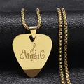 Macro shot of gold guitar pick necklace with Music and treble clef engraving detail - Gold