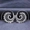 Macro view of spiral hollow carved stainless steel earrings on black leather texture - Silver