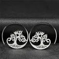 Detalle de pendientes bohemios plateados con diseño de árbol sobre textura de cuero negro - Plateado