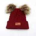 Dettaglio del berretto in maglia a trecce bordeaux con doppi pompon e logo in pelle - Bambini / Borgogna