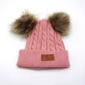 Dettaglio del berretto in maglia a trecce rosa con doppio pompon marrone e patch in pelle - Bambini / Rosa