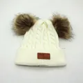 Dettaglio cappello in maglia per bambini con due pompon e toppa in pelle con logo - Bambini / Bianco latte