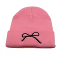Close-up of pink knitted beanie featuring black bow embroidery and ribbed texture - One Size / Pink