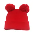 Dettaglio macro del berretto in maglia rossa con doppio pompon e trama a coste invernali - Taglia unica / Rosso