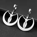 Detail of silver goddess earrings with crescent moon and spiral on dark background - Silver