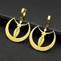 Close-up of golden moon goddess earrings with spiral symbol on a black leather texture - Gold
