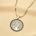 Detail van een levensboom hanger aan een zilveren slangenketting op beige stof - Zilver/Zwarte Zirkonia