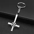 Detail of silver inverted cross keychain with pentagram star on black leather background - Silver