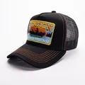 Close-up of STATION embroidery and orange contrast stitching on black mesh trucker hat - Adjustable / Black
